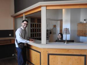 a man standing in front of a counter with a woman at Hotel Argo Lindau in Lindau