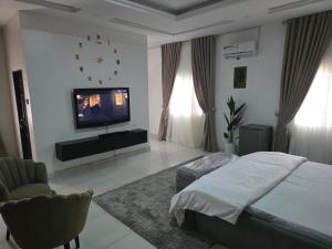a bedroom with a bed and a flat screen tv at House 27 in Idu