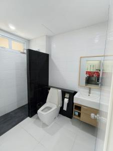 a white bathroom with a toilet and a sink at Home Valot Bed and Breakfast in Lan Saka