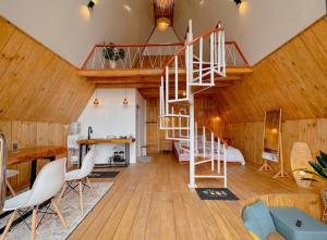 a living room with a spiral staircase in a house at Griya Cabin 5 Dieng in Diyeng