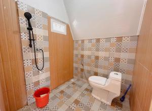 a small bathroom with a toilet and a shower at Griya Cabin 5 Dieng in Diyeng