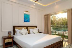a bedroom with a large white bed and a balcony at Yellowstone Resort Arambol in Arambol +27 photos