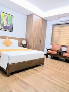 a bedroom with a bed and a couch in it at Vũ Gia Hotel in Hanoi
