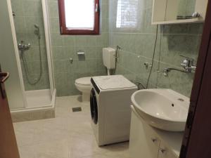 a bathroom with a toilet and a sink and a shower at Apartmani Antica in Cres +26 photos