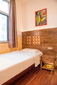 a bedroom with two beds and a window at Haikou Banana Hostel in Haikou