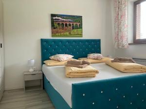 a bed with a blue headboard in a bedroom at APT 16 Telgart in Telgárt