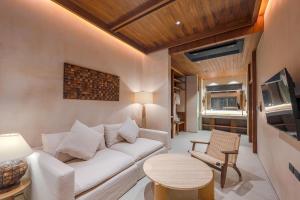 a living room with a white couch and a table at Peace House Koh Phi Phi in Phi Phi Islands