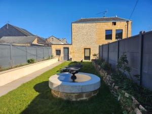 a garden with a fountain in the middle of a yard at L'Atypique - Piscine chauffée - Maison en Pierre - Espaces insolites in Floing