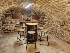 a room with a barrel and stools in a building at L'Atypique - Piscine chauffée - Maison en Pierre - Espaces insolites in Floing