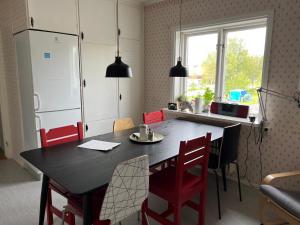 a kitchen with a black table and red chairs at Hook&Cup in Sorsele +10 photos