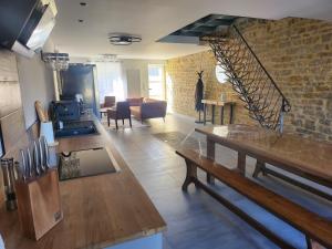 a living room with a wooden table and a brick wall at L'Atypique - Piscine chauffée - Maison en Pierre - Espaces insolites in Floing