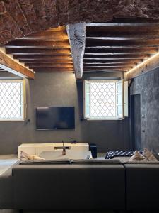 a room with a couch and a tv and two windows at G11 Carpi in Carpi
