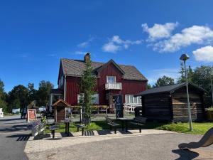 a red house with benches in front of it at Hook&Cup in Sorsele