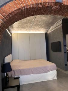 a bedroom with a bed and a brick wall at G11 Carpi in Carpi