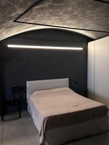 a bedroom with a white bed and a black wall at G11 Carpi in Carpi