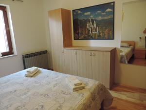 a bedroom with a bed and a painting on the wall at Apartmani Antica in Cres