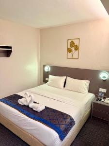 a hotel room with a bed with towels on it at Hotel first garden in Kuantan +6 photos