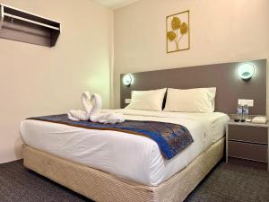 a bedroom with a large bed with two swans on it at Hotel first garden in Kuantan