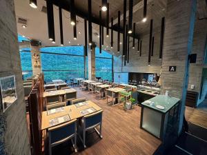 a restaurant with tables and chairs in a room at Onsen Papawaqa in Tai'an