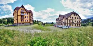 a couple of buildings with cars parked in a field at APT 16 Telgart in Telgárt