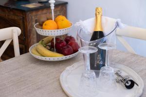 a table with a bowl of fruit and a bottle of champagne at Casa Torre Adults Only storia e relax a Fiorenzuola in Fiorenzuola di Focara