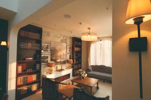 ein Wohnzimmer mit Sofa, Tisch und Büchern in der Unterkunft RIN Hotel Da Lat in Xuan An