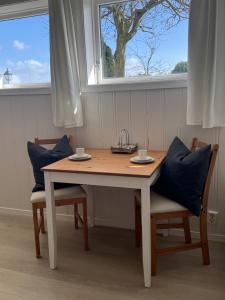 a wooden table with two chairs and a window at Sokkelleilighet på Sola in Sola +4 photos