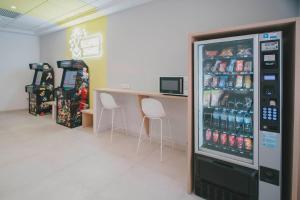 a soda vending machine in a store with two chairs at Sercotel Carlos III in Cartagena
