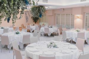 a banquet hall with white tables and white chairs at Sercotel Carlos III in Cartagena