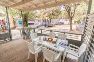 a white table and chairs on a porch with a table and chairsktop at Club del Sole Marina Julia Family Collection in Marina Julia