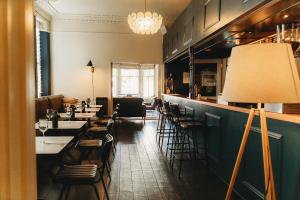 a restaurant with a bar with tables and chairs at Hotel VARA in Truro