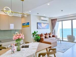 a living room with a couch and a table with flowers at CĂN HỘ NGHĨ DƯỠNG CAO CẤP THE SÓNG VŨNG TÀU-THE SONG APARTMENT LeeHuy in Vung Tau