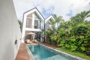 an exterior view of a house with a swimming pool at Modern 2BR Villa Samudra Ocean View Nusa Dua in Ungasan