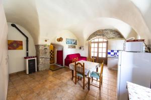 a kitchen and dining room with a table and a refrigerator at Ginestra in Cipressa +17 photos