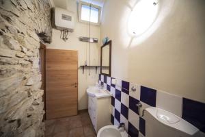 a bathroom with a sink toilet and a stone wall at Ginestra in Cipressa