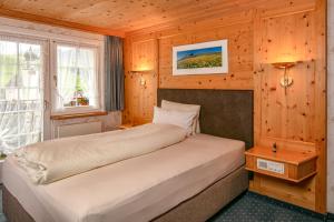 a bedroom with two beds in a wooden room at Hotel Alpenblick in Weissbad