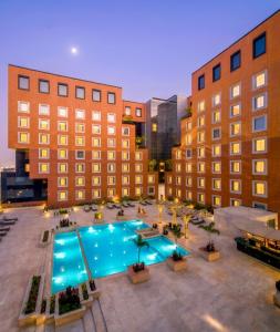 an overhead view of a pool in a courtyard with buildings at The Orchid Hotel Hinjewadi Pune in Pune