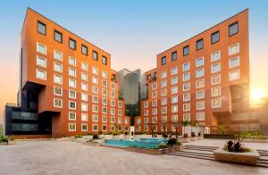 two tall buildings with a pool in a courtyard at The Orchid Hotel Hinjewadi Pune in Pune