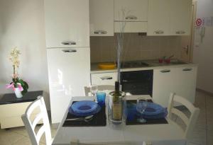 a kitchen with a table with blue plates on it at Appartamento Premier in Gatteo a Mare