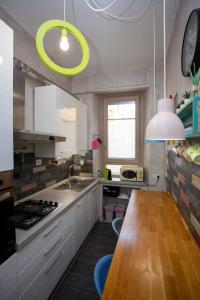 a kitchen with white cabinets and a wooden table at Come a Casa Pretty Apartment in Lido di Ostia