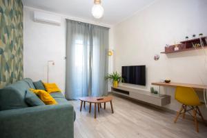 a living room with a blue couch and a tv at Come a Casa Pretty Apartment in Lido di Ostia