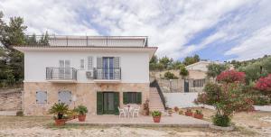 a house with a balcony and a table and chairs at Casaverde Gargano in Mattinata