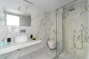 a white bathroom with a sink and a shower at Alyssium in Benitses +37 photos