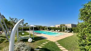 a swimming pool in a yard with chairs around it at Tenuta Pigliano Hotel in Bagnolo del Salento