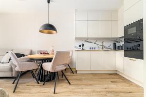 a kitchen and dining room with a table and chairs at Your Holidays Forest D141 in Międzyzdroje