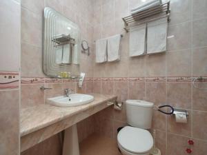 a bathroom with a sink and a toilet and a mirror at Hamkor hotel in Andijan +20 photos