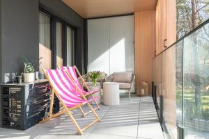 a pink rocking chair sitting on a patio at Your Holidays Forest D141 in Międzyzdroje