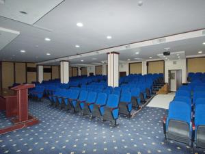 a large room with blue chairs and a podium at Hamkor hotel in Andijan