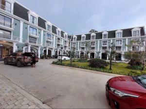 a red car parked in front of a large building at Camly Resort DaLat in Ấp Ða Lợi