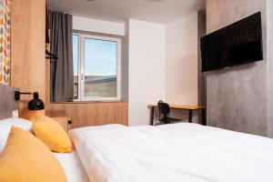 a hotel room with a bed and a window at Urban Ring Hotel in Ljubljana